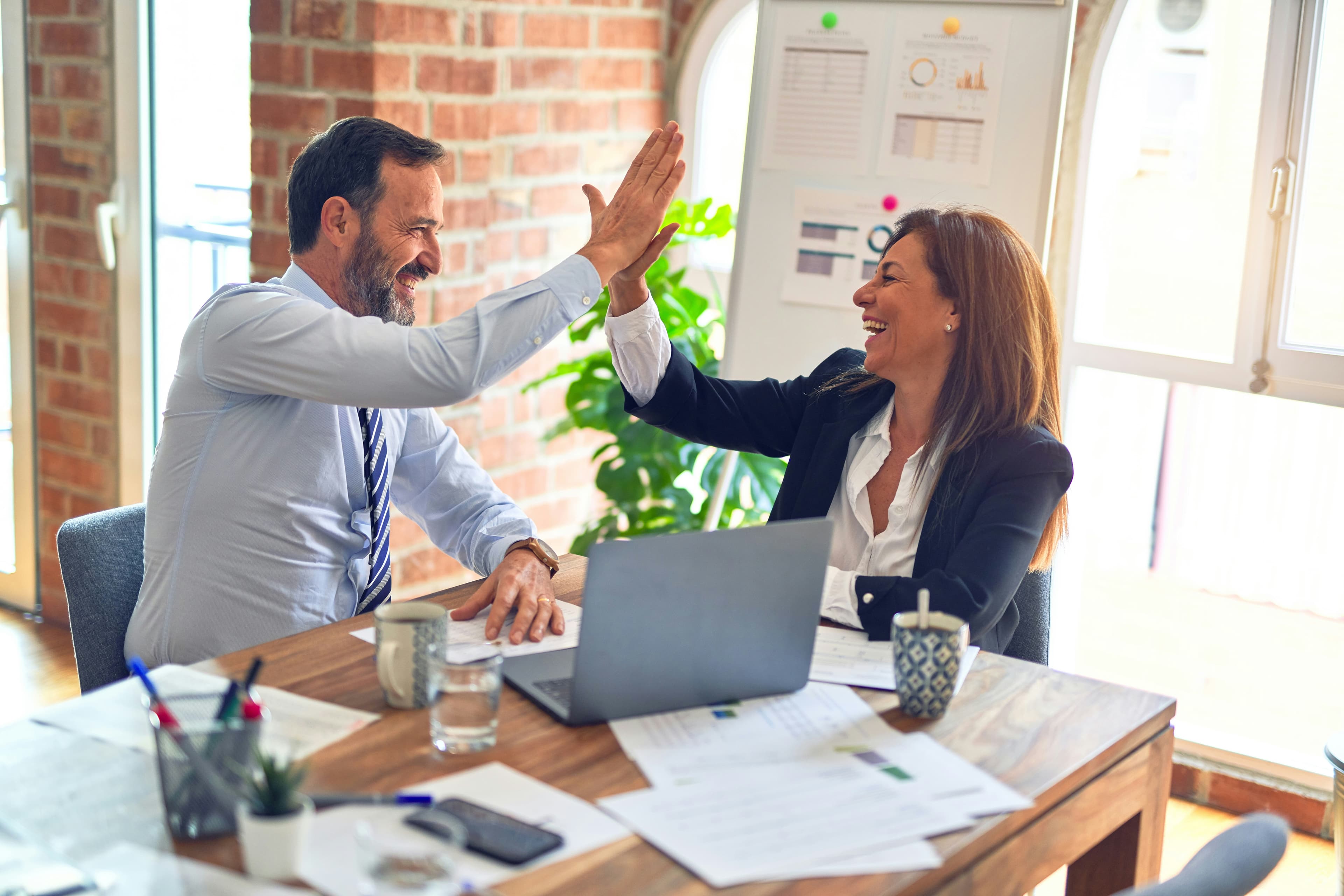 Two people celebrating with high five during consulting session